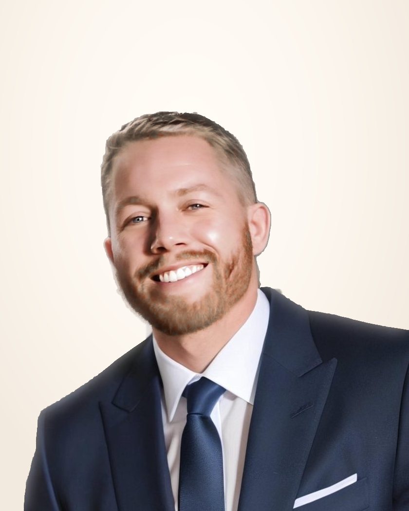 Me, smiling, in a navy suit, standing in an open doorway full of light